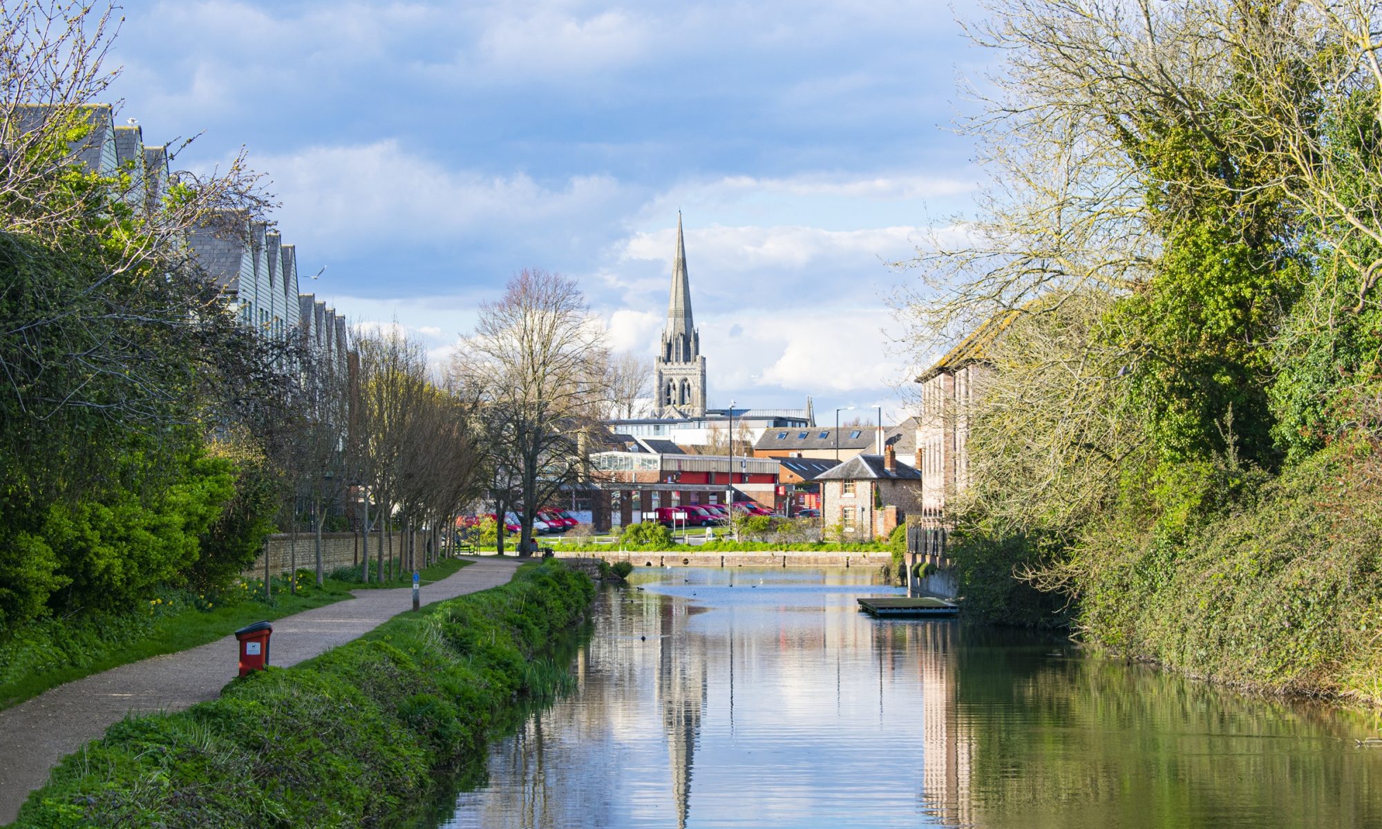 House and boats in the Chichester marina, river, reflection on the water, clouds, blue sky, summer day in Chichester city, West Sussex